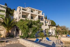 un edificio con sillas azules delante de él en Apartments Regina Maris, en Klek
