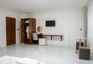 a white room with a bed and a desk at Empire House, Phnom Penh in Phnom Penh