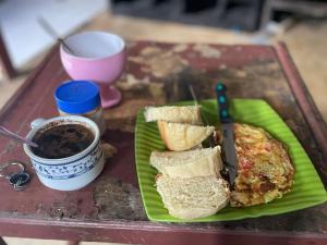 a plate of food with a sandwich and a cup of coffee at Hidayah homestay in Kelimutu