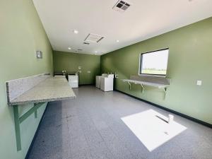 an empty room with green walls and a window at Crosby Travel Lodge and RV Park in Crosby
