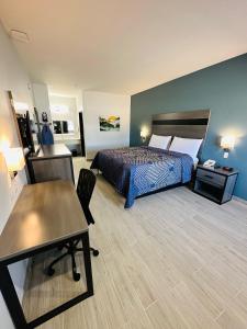 ein Hotelzimmer mit einem Bett und einem Tisch in der Unterkunft Crosby Travel Lodge and RV Park in Crosby