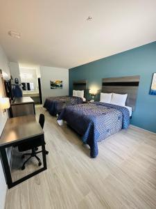 ein Hotelzimmer mit 2 Betten und einem Schreibtisch in der Unterkunft Crosby Travel Lodge and RV Park in Crosby