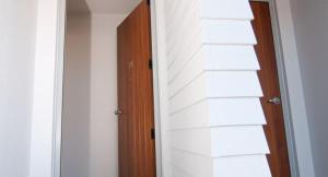 una puerta que conduce a una habitación con una pared blanca en Broadway Motel & Miro Court Villas en Matamata