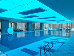 a swimming pool in a building with blue lighting at Le Meridien Zhongshan in Zhongshan
