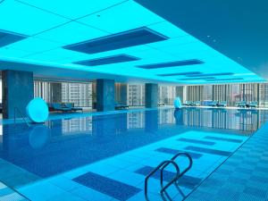 - une piscine dans un bâtiment à l'éclairage bleu dans l'établissement Le Meridien Zhongshan, à Zhongshan