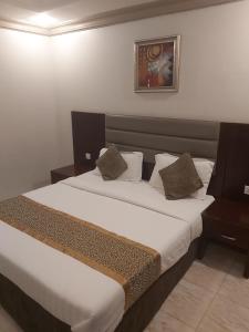 ein Schlafzimmer mit einem großen Bett mit zwei Kissen in der Unterkunft دانات الخليج in Khobar