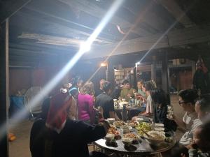 薩帕的住宿－May Kim Ta Phin Homestay，一群坐在餐桌上吃食物的人