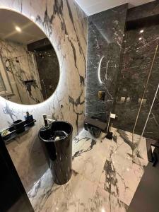 ein Bad mit einem Waschbecken und einer Dusche mit einem Spiegel in der Unterkunft Luxury apartment Betina in Betina
