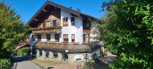 a large white house with flowers on the balcony at Ferienwohnung mit Sauna am Alpsee in Bühl am Alpsee