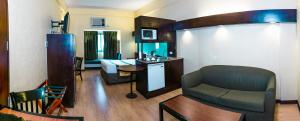 sala de estar con sofá y silla en una habitación en Microtel by Wyndham Cabanatuan, en Cabanatúan