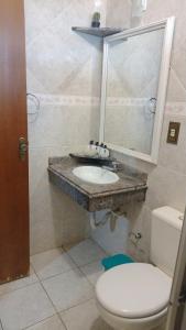 a bathroom with a sink and a toilet at Estância Stela Pousada in Olímpia