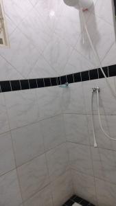 a shower with a hose in a bathroom at Estância Stela Pousada in Olímpia