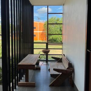 a room with a bench and a large window at J2 INN in Uttaradit