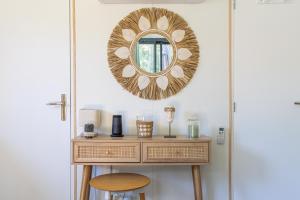 a dressing table with a mirror on a wall at LES LODGES TAIZEN, séjour SPA- sans enfants in Saint-Cannat
