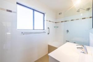 Un baño blanco con lavabo y ducha en Intrepid, 15 3 Intrepid Close - right on the beachfront and WiFi, en Shoal Bay 21 fotos más