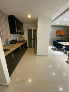 een keuken met een witte tegelvloer en een tafel bij Exclusivo departamento con todos los servicios in Humaya