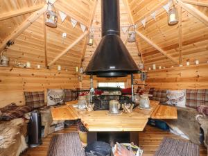 a living room with a large stove in a log cabin at Fell Cottage in Wigton