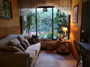 a living room with a couch and a large window at Habitación matrimonial deluxe Casa Tierra Elquina in Vicuña