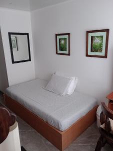 un letto in una camera con due immagini sul muro di HABITACIÓN CON BAÑO PRIVADO EN SECTOR TURÍSTICO a Bogotá