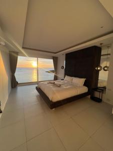 a bedroom with a bed with a view of the ocean at The Beach Residence in Koh Samui