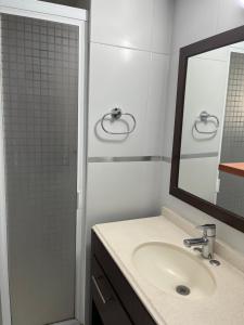 y baño con lavabo y ducha con espejo. en Cozy Wine Pedregal en Ciudad de México