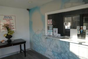 a room with a counter with a window and a table at Avenue Motel in Gardena