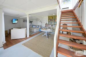 una scala in un soggiorno con divano e tavolo di Cape Villa a Cape Bridgewater