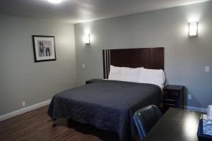 a hotel room with a bed and a table at Avenue Motel in Gardena