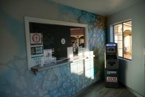 a gas station with an atm machine in a room at Avenue Motel in Gardena