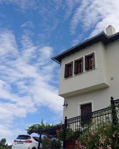 een wit huis met twee ramen en een auto bij Olga Studios in Tsagarada