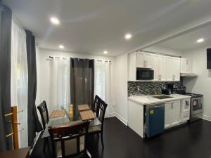 a kitchen with a table and chairs and a counter top at Oshawa Downtown, 2 Bed rooms house fully furnished in Oshawa