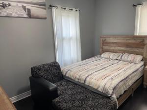 1 dormitorio pequeño con 1 cama y 1 silla en Oshawa Downtown, 2 Bed rooms house fully furnished en Oshawa