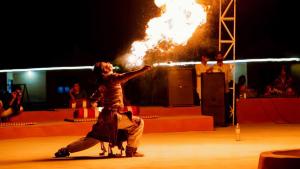 a group of people on a stage with fire at Serendipity desert Camp in Thar Desert in Jaisalmer