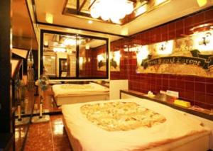 a room with three beds with a large pizza at ホテル　アイネ　五條店 in Nohara