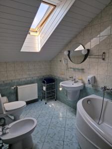 a bathroom with two toilets and a sink and a mirror at Hotel Linda - Helvita in Liepāja