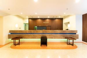 a hotel lobby with a front desk and two benches at Hotel Montoview Yonezawa in Yonezawa
