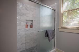 a shower with a glass door in a bathroom at Southern Sophistication and Charm in the Heart of Cooper Young in Memphis