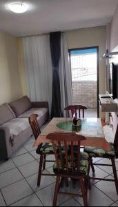 sala de estar con mesa, sillas y sofá en Condomínio Euro, en Natal