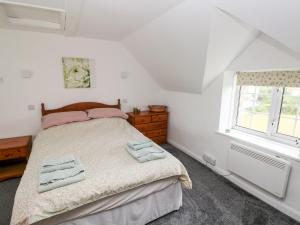 a bedroom with a bed with two towels on it at No 2 New Cottages in Pembroke