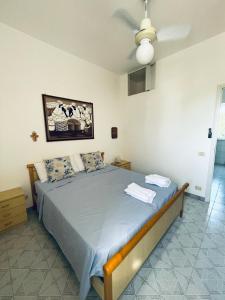 - une chambre avec un lit et un ventilateur de plafond dans l'établissement Casita Luzmila, à Torre Canne