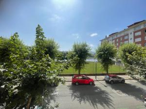 two cars parked in a parking lot with trees at Habitaciones Arrisal in Bilbao