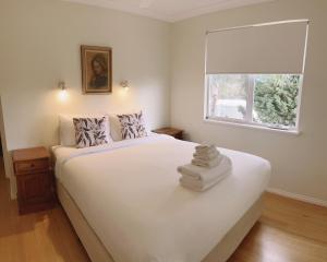 1 dormitorio con 1 cama blanca grande y ventana en Wildwood Valley, en Yallingup