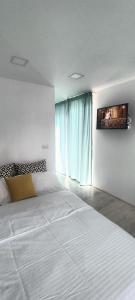 a bedroom with a large white bed and a window at Tiny Village Mamaia Nord - House 4 in Mamaia Nord