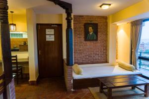 a living room with a couch and a brick wall at Thagu Chhen, a Boutique Hotel in Bhaktapur