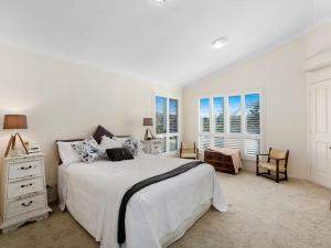 a bedroom with a bed and a dresser and windows at Hastings Paradise in Cabarita Beach