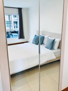 a mirror in a bedroom with a bed and a window at The Lodge @ Min Residence in Bangkok
