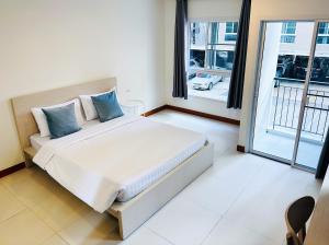 a bedroom with a large bed and a large window at The Lodge @ Min Residence in Bangkok