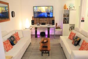 a living room with a white couch and a tv at Mathilde Villa Grand Baie in Grand Baie