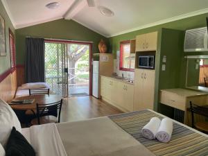 cocina y sala de estar con cama y mesa en Big4 Aussie Outback Oasis Holiday Park, en Charters Towers