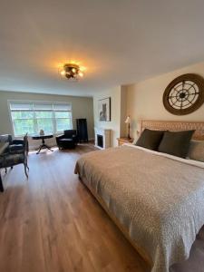 a bedroom with a large bed and a clock on the wall at Centre Gate House Licence# 117-2023 in Niagara on the Lake